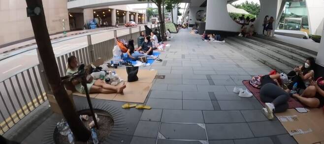 홍콩 시내 지하철역 인근 거리에서는 이주 가사노동자 여성들이 텐트를 치거나 돗자리 깔고 쉬는 풍경. 여행 유튜버 ‘노마드션’ 영상 갈무리.