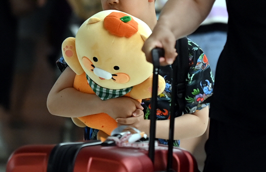 현충일 징검다리 연휴 마지막 날인 6일 오후 서울 강서구 김포공항 국내선 도착장에서 한 어린이가 감귤모자를 쓴 인형을 들고 들어오고 있다.  박윤슬 기자