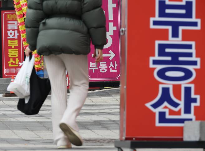 서울 한 부동산중개사무소 앞을 시민이 지나가고 있다.[연합]