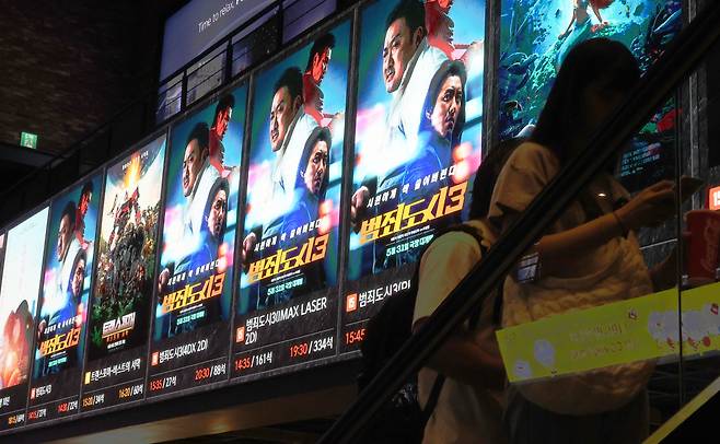 지난 6일 서울 시내 한 극장에서 관람객들이 영화 '범죄도시 3' 홍보물 앞을 지나고 있다./연합뉴스