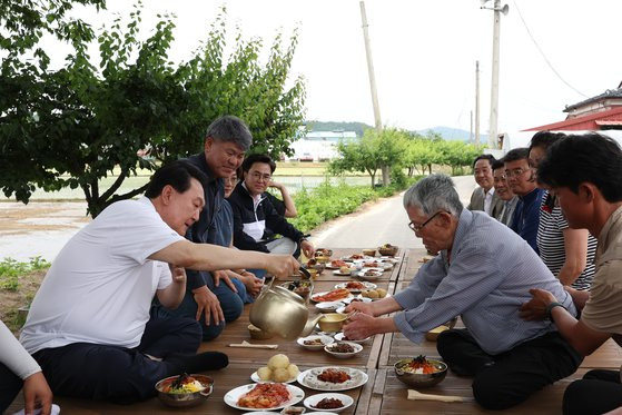 윤석열 대통령이 7일 충남 부여군 임천면의 '꿈에영농조합법인' 모내기 현장을 방문, 모내기를 마친 뒤 주민들과 새참을 함께하고 있다. 연합뉴스