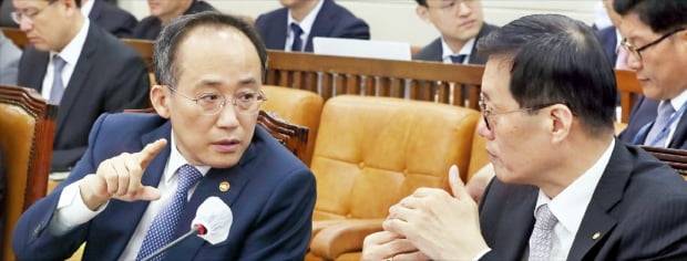 지난달 22일 추경호 부총리 겸 기획재정부 장관(왼쪽)과 이창용 한국은행 총재가 국회에서 열린 기획재정위원회 전체회의에서 이야기를 나누고 있다.  뉴스1