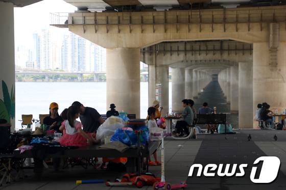 지난 6일 서울 영등포구 여의도 한강공원에서 시민들이 그늘 밑에 앉아 더위를 식히고 있다./사진=뉴스1