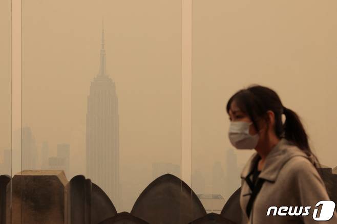 7일 (현지시간) 캐나다에서 발생한 산불의 영향으로 미국 뉴욕 맨해튼의 엠파이어 스테이트 빌딩 주변의 잿빛으로 뒤덮인 거리를 주민이 마스크를 쓰고 걷고 있다. 2023.6.8 ⓒ 로이터=뉴스1 ⓒ News1 우동명 기자
