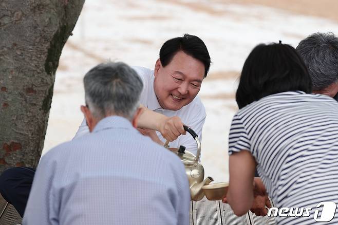 윤석열 대통령이 7일 충남 부여군 임천면 '꿈에영농조합법인'의 모내기 작업 현장을 방문해 모내기 작업에 참여한 후 농민들과 새참을 함께 하고 있다. (대통령실 제공)/뉴스1 ⓒ News1 오대일 기자