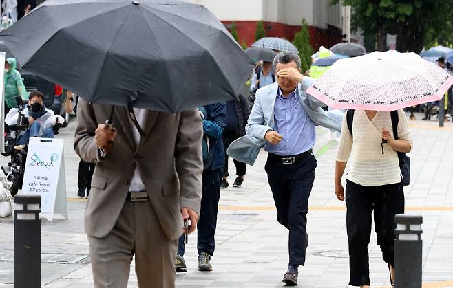 전국 곳곳에 비가 내린 8일 오후 서울 중구 세종대로에서 우산을 준비하지 못한 시민이 걸음을 재촉하고 있다./뉴스1