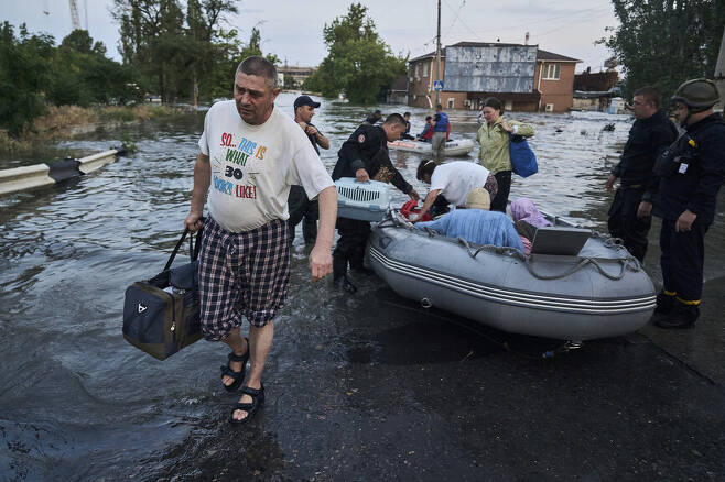 6일(현지시각) 우크라이나 남부 노바 카호우카댐이 붕괴되면서 홍수가 발생한 헤르손에서 구조대원들이 주민’들을 구조하고 있다. AP 연합뉴스