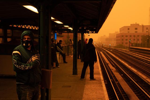 7일 캐나다 산불로 짙은 연기가 깔린 미국 뉴욕시에서 한 시민이 필터 마스크를 쓴 채 지하철을 기다리고 있다. 뉴욕=AFP 연합뉴스