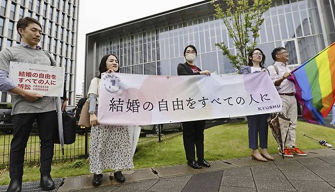 일본에서 동성결혼 인정을 요구하는 소송을 제기한 성소수자 측 변호사들이 8일 후쿠오카 지방재판소 앞에서 결혼의 자유를 보장할 것을 요구하는 현수막을 펼쳐 들고 있다./교도AP연합뉴스
