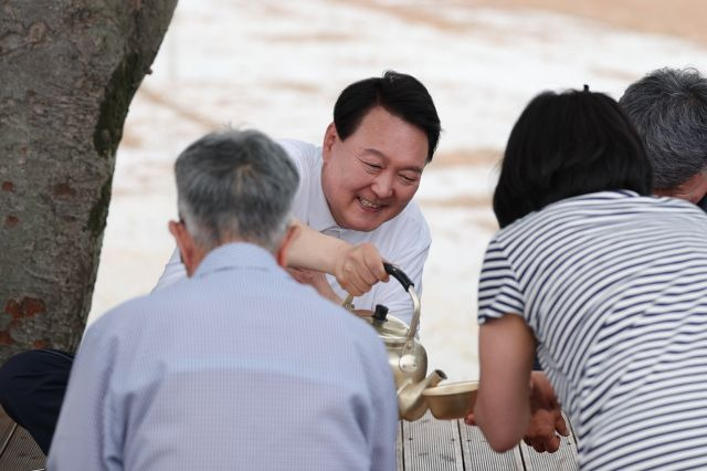 윤석열 대통령이 7일 충남 부여군 임천면의 '꿈에영농조합법인' 모내기 현장을 방문, 모내기를 마친 뒤 주민들과 새참을 함께하고 있다. 대통령실 제공