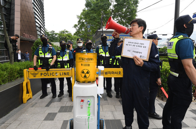 녹색연합 회원이 7일 오후 서울 종로구 일본대사관 앞에서 후쿠시마 핵오염수 방류의 위험성을 알리기 위해 정수기를 소재로 활용한 '누구도 마실 수 없는 핵오염수' 퍼포먼스를 벌이고 있다. 이한형 기자