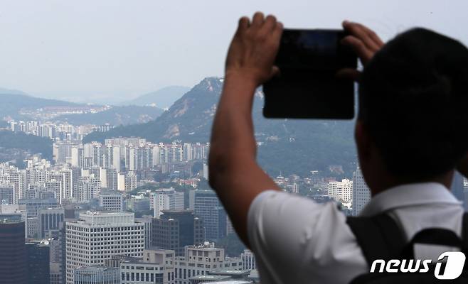 (서울=뉴스1) 김성진 기자 = 4일 서울 중구 남산 전망대를 찾은 시민들이 도심 속 아파트 단지를 바라보고 있다.   전매 제한이 풀린 이후 서울 입주·분양권 거래가 급증한 것으로 나타났다. 업계에서는 향후 실거래 의무까지 폐지되면 거래량이 더 늘고 가격도 상승세를 탈 것으로 예상했다.  서울부동산정보광장에 따르면 전날 기준 지난 4~5월 서울 아파트 분양권·입주권 전매 거래량은 101건으로 집계됐다. 올해 1분기 전체 거래량(50건)의 2배 이상이다. 2023.6.4/뉴스1  Copyright (C) 뉴스1. All rights reserved. 무단 전재 및 재배포 금지.