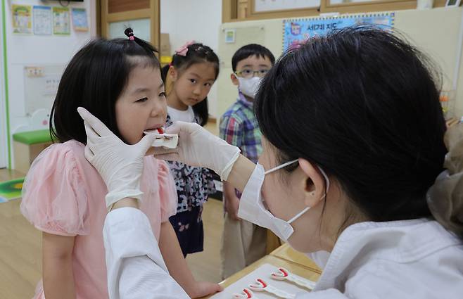 구강보건의 날을 앞둔 8일 서울 송파구 잠신초등학교 병설 유치원에서 보건소 직원들이 원생들에게 구강검진 및 불소 치료를 하고 있다.