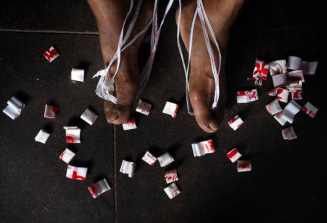 바부 카지 마하르잔(82)이 6월 4일 네팔 랄릿푸르 파탄의 자택에서 플라스틱 우유 포장 폐기물을 이용해 핸드백을 만들고 있다./EPA 연합뉴스