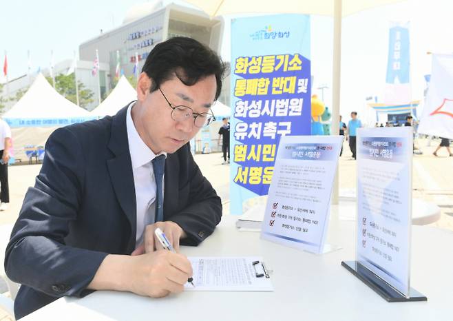 정명근 화성시장이 9일 '수원·화성등기소 통·폐합 반대 및 화성시법원 유치 범시민 서명운동'을 알리고 서명하고 있다. / 사진제공=화성시