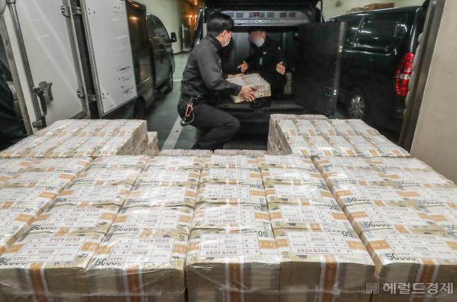 설 명절을 일주일 앞둔 16일 서울 강남구 한국은행 강남본부에서 현금 운송 관계자들이 시중은행에 공급될 설 자금 방출 작업을 하고 있다. 1000장씩 묶인 5만원권과 1만원권 등 지폐들은 비닐 등에 묶여 각 지역으로 옮겨진다(사진은 기사 내용과 직접적 관련없음).[사진공동취재단]