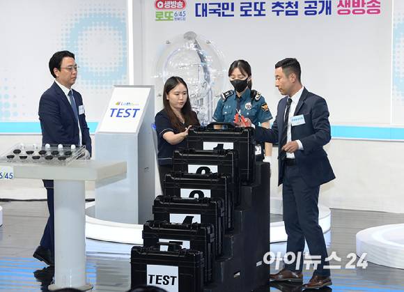 10일 오후 서울 마포구 상암동 MBC 골든마우스홀에서 열린 '대국민 로또6/45 추첨 공개방송'을 앞두고 경찰관 입회 하에 추첨볼 5개 세트 봉인 해제를 하고 있다. [사진=정소희 기자]