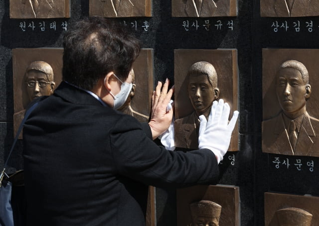 26일 오전 경기도 평택시 해군 제2함대 사령부에서 열린 '제13주기 천안함 46용사 추모식'에서 유가족이 추모비에 새겨진 얼굴을 어루만지고 있다. / 사진=연합뉴스