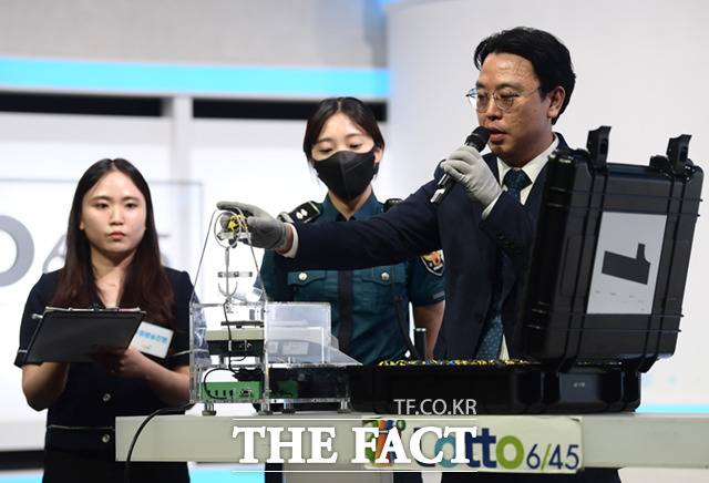 동행복권 직원이 생방송에 앞서 참관인과 경찰 입회 하에 추첨볼 규격을 체크하고 있다. 추첨볼 기준 무게는 4g(5% 오차 범위 3.8~4.2g), 기준 둘레는 44.5mm(오차범위 2.5% 43.4~45.6mm)이다.