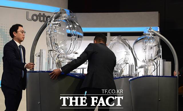 동행복권 직원들이 추첨기 '비너스' 를 생방송 무대에 설치하고 있다. 추첨기 장애를 대비해 본 추첨기와 예비 1,2 추첨기 총 3대를 설치한다.