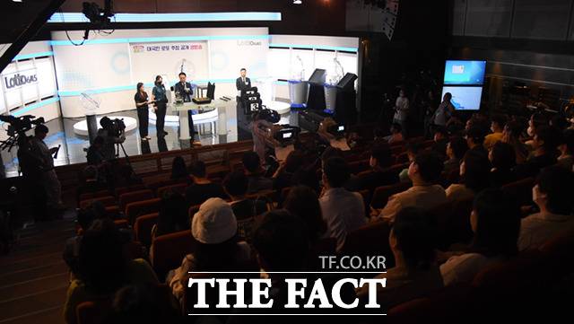 150명 참관인 중 지원자를 받아 무작위로 선정한 공의 무게를 측정하고 있다.