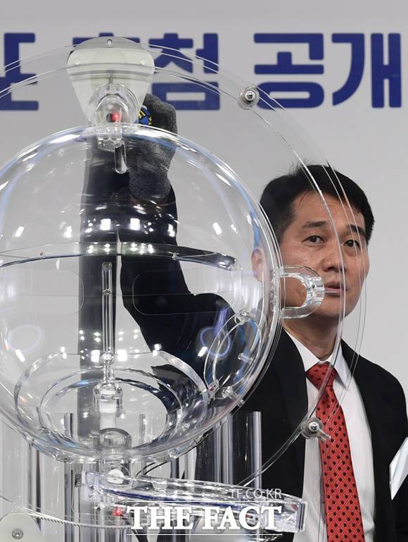 이 씨가 임의로 고른 공을 직원이 추첨기 상단 가운데 구멍에 설치된 RFID칩 인식기에 갖다 대 작동 여부를 확인하고 있다.