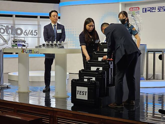 10일 서울 상암 MBC 골든마우스홀에서 경찰관 입회 하에 동행복권 관계자가 로또 추첨볼 봉인을 해제하고 있다. /윤희훈 기자
