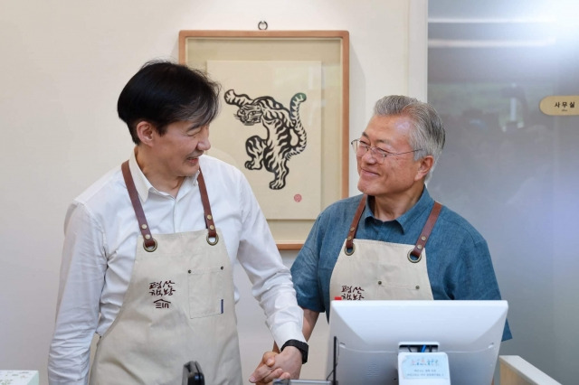 조국 전 법무부 장관이 지난 10일 경남 양산시 평산책방에서 문재인 전 대통령과 손 잡으며 웃고 있다. 조 전 장관 페이스북 캡처