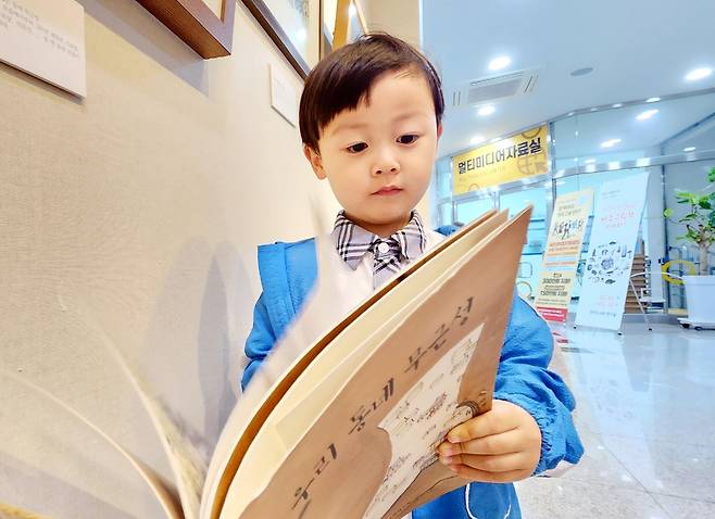 전시회에서 그림책 보는 어린이 (제주=연합뉴스) 변지철 기자 = 지난 5일 제주한라도서관 1층 전시실에서 제주그림책연구회 창립 20주년 기념 전시회를 찾은 어린이가 그림책을 보고 있다. 2023.6.11