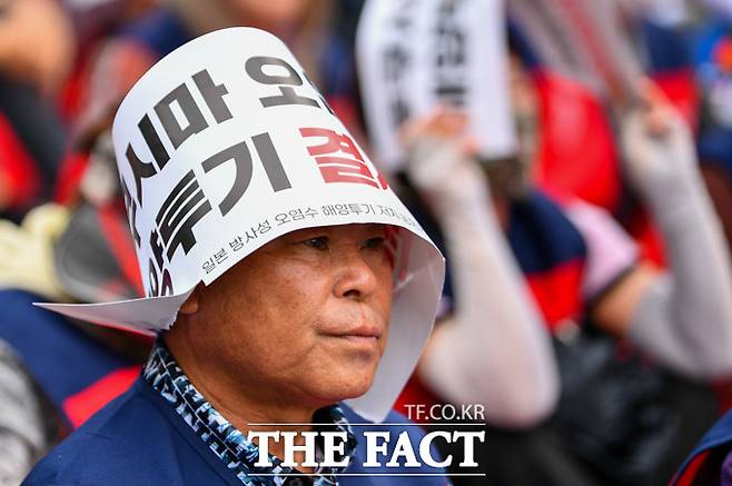 전국어민회총연맹 회원들과 일본 방사성 오염수 해양투기 저지 공동행동이 12일 오후 서울 영등포구 국회의사당 앞에서 주최한 '전국어민대회' 참가자가 팻말을 머리에 말아 쓰고 있다./장윤석 인턴기자