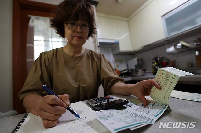 [서울=뉴시스] 백동현 기자 = 21일 오후 서울 시내 한 가정집에서 시민이 공공요금 고지서를 살펴보고 있다. 이날 국회 산업통상자원중소벤처기업위원회 소속 더불어민주당 김회재 의원이 한전에서 제출받은 자료에 따르면 한국전력이 올해 적자를 해소하려면 내달 kWh당 261원 수준의 전기 요금 인상이 필요하다고 밝혔다. 이는 통상 평균 전력을 사용하는 가구당 전기 요금을 8만원 이상 인상해야 하는 수준이다. 2022.09.21. livertrent@newsis.com