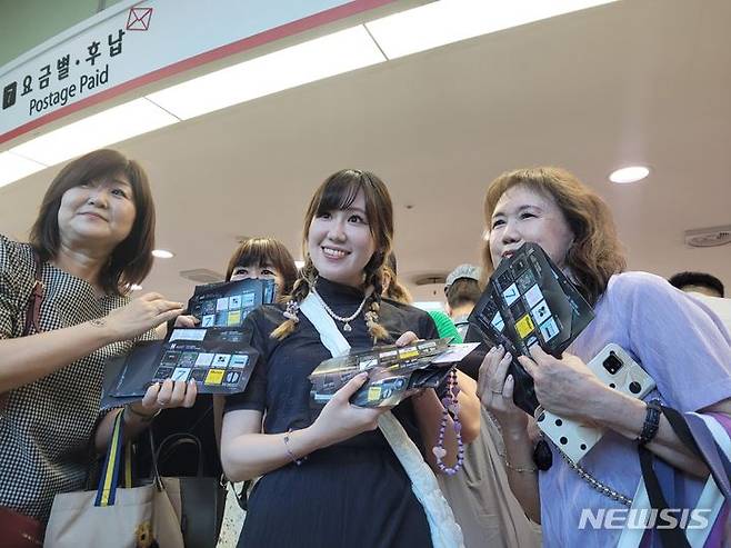 [서울=뉴시스]김래현 기자 = 13일 오전 서울 중구 서울중앙우체국에서 방탄소년단(BTS) 기념우표를 구매한 BTS 팬들이 우표를 들고 포즈를 취하고 있다. 2023.6.13. rae@newsis.com *재판매 및 DB 금지