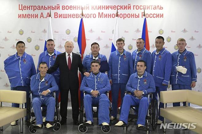 [모스크바=AP/뉴시스] 블라디미르 푸틴 러시아 대통령은 '러시아의 날'인 12일(현지시간) 모스크바에 있는 중앙군사병원을 찾아 우크라이나 전쟁에서 부상 당한 병사들과 기념 촬영을 하고 있다. 2023.06.13.