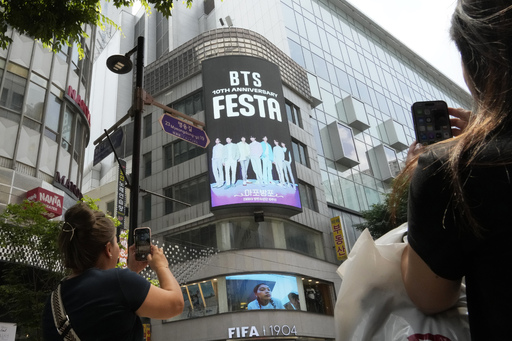 A screen shows an image of K-pop band BTS to celebrate its 10th debut anniversary in Seoul, South Korea, Tuesday, June 13, 2023. AP