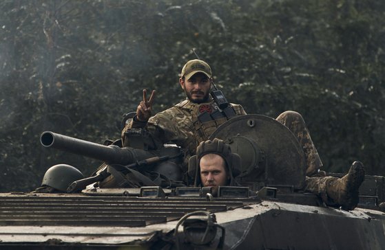 러시아가 점령했던 우크라이나 북동부 하르키우 인근의 전략적 요충지인 이지움을 수복한 우크라이나 군인이 BMP-2 보병전투차를 타고 승리의 V자를 그려 보이고 있다. AP=연합뉴스