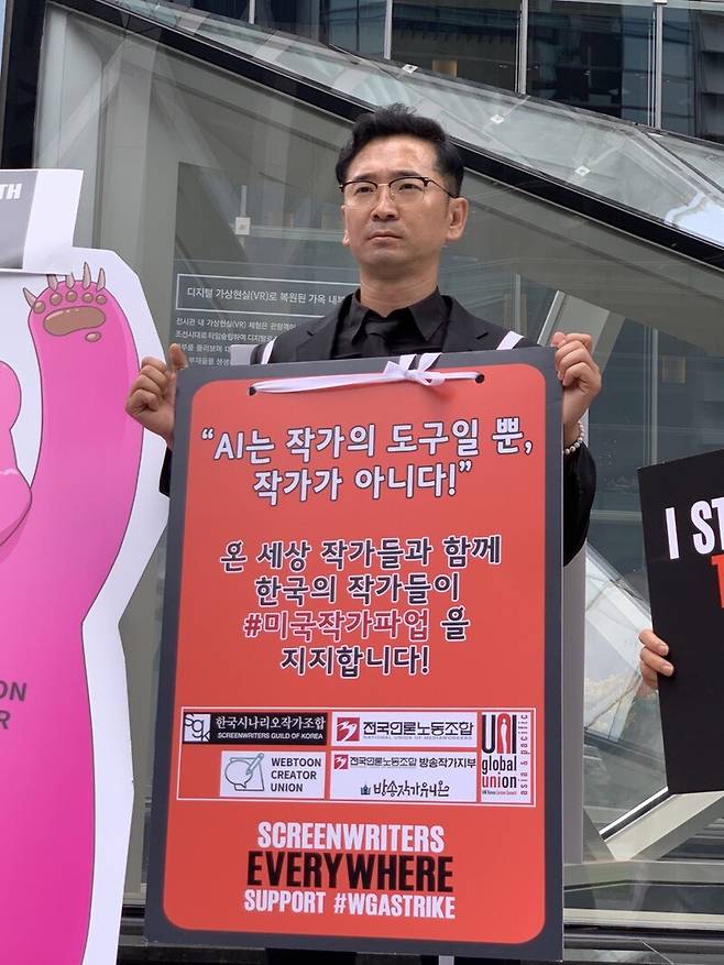 ▲14일 오후서울 종로구 넷플릭스 한국지사 건물 앞에서 진행된 미국작가조합 파업지지 연대 시위에서 발언하는 이승현 한국시나리오작가조합 소속 작가. 사진=윤유경 기자.
