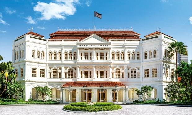 영국 콜로니얼 양식으로 지어진 래플스 싱가포르. 지금과 같은 모습으로 1915년 증축됐다. 로비 앞 여행객들을 태운 마차가 지나던 길은 100여 년 전과 마찬가지로 자갈로 이뤄져 있다.  래플스호텔 제공