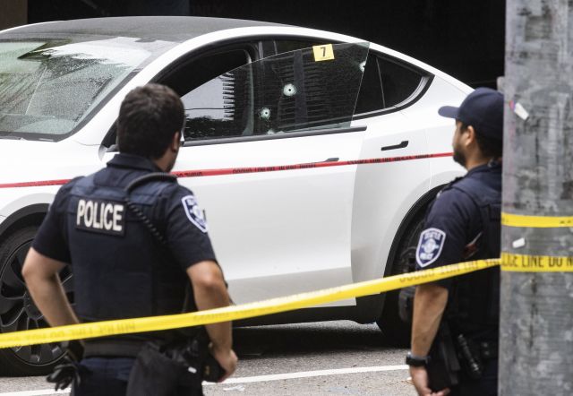 미국 시애틀 경찰들이 13일(현지시간) 벨타운 인근에서 총격으로 피해를 본 차량을 확인하고 있다. AP연합뉴스
