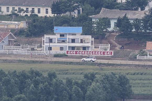 북녘의 SUV - 30일 경기도 파주시 서부전선 비무장지대(DMZ) 도라전망대에서 바라본 북한 개성공단 인근 마을에서 SUV 차량이 선전구호 앞을 이동하고 있다. 2023.5.30 연합뉴스