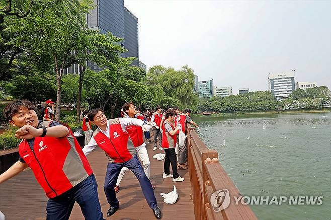 롯데월드타워, '아름다운 석촌호수 만들기' 실천 (서울=연합뉴스) 지난 14일 서울 송파구 석촌호수에서 롯데물산 임직원들이 아름다운 석촌호수 만들기 활동의 일환으로 'EM흙공 던지기'를 하고 있다. 2023.6.15 [롯데물산 제공. 재판매 및 DB 금지] photo@yna.co.kr