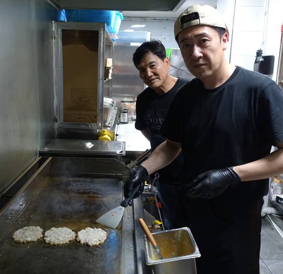 전복 패티를 굽는 최성훈(오른쪽) 셰프와 원천 레시피 개발자 채성태씨. [사진 이택희]