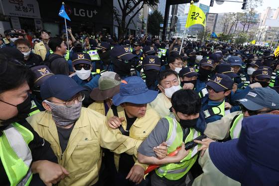 Officials from the Daegu Metropolitan Government and Daegu’s Jung District Office, left, clash with police officers on Saturday as they attempt to stop an LGBTQ festival from being held. [NEWS1]