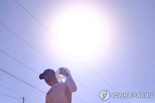 폭염 속 물통을 이고 가는 남성 멕시코 시우다드 후아레스 [로이터 연합뉴스]