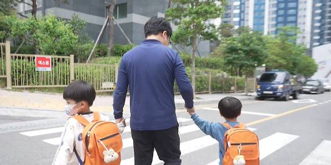 남경호 씨가 유치원 버스에서 내린 두 아이를 집으로 데려가고 있는 모습