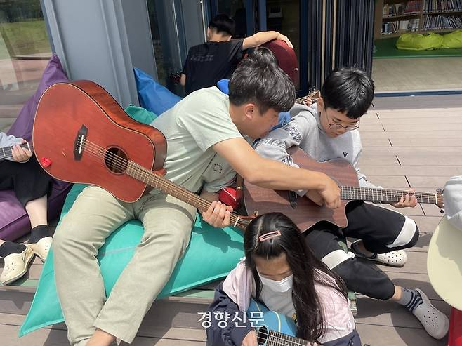 전남 순천시 송산초등학교에서 교사가 야외 공간에서 빈백에 앉아 학생들에게 기타를 가르쳐주고 있다. 김나연 기자