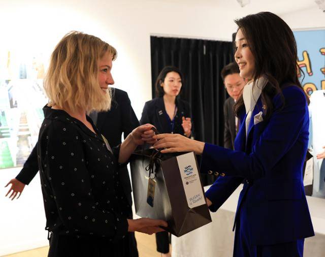 윤석열 대통령 부인 김건희 여사가 20일(현지시간) 파리 주프랑스한국문화원에서 외신기자들과 '2023 한국문화제 테이스트 코리아' 부산 특별전을 관람한 뒤 외신기자에게 ‘Busan is ready’와 ‘Hip Korea’ 메시지가 각각 담긴 키링을 기념품으로 전달하고 있다. 파리=뉴시스