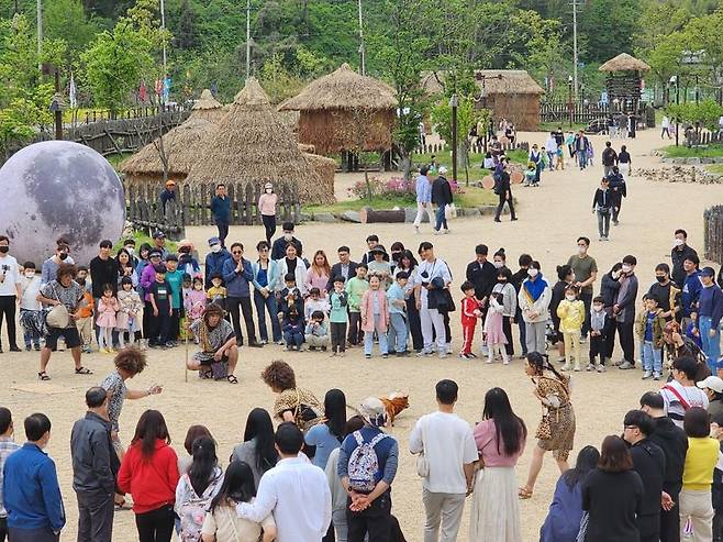 전남 화순군은 오는 23일부터 7월 29일까지 고인돌 유적지 내 선사체험장에서 '한여름 밤의 버스킹'을 개최한다고 밝혔다. 사진은 관광객들이 고인돌 선사체험장에서 생활 재현 공연을 즐기고 있는 모습. 화순군 제공