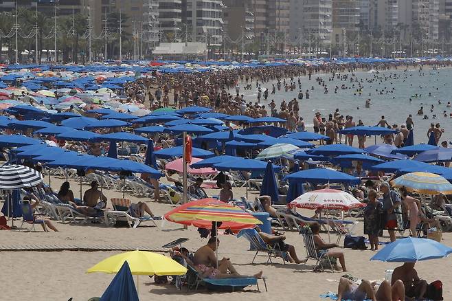 여름의 첫날(하지)인 21일 스페인 베니돔의 해변에서 해수욕객들이 따뜻한 날씨를 즐기고 있다. 앞으로 42도까지 기온이 올라갈 수 있다는 예보가 나왔다. EPA 연합뉴스