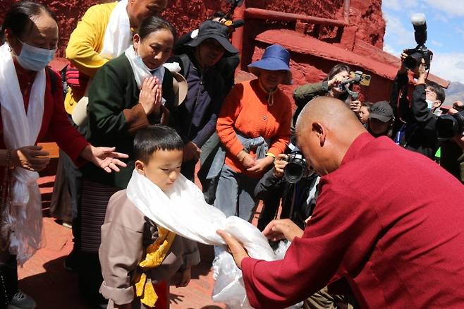 중국 티베트 포탈라궁 18일 중국 티베트 라싸의 포탈라궁에서 승려가 한 어린이의 목에 '하다'(티베트에서 환영을 뜻하는 흰 천)를 걸어주고 있다. [촬영 한종구 특파원]