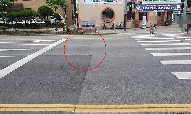 지난 15일 충북 청주시 도로에 정지선이 기존보다 2m 정도 물러선 곳에 새롭게 그어진 가운데 지워진 기존 정지선 흔적(빨간 동그라미)이 보인다.